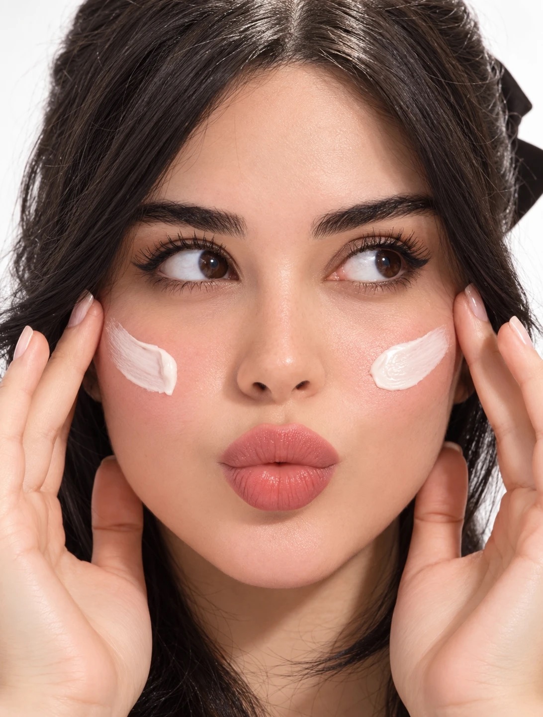 Darya with two swatches of cream on her cheeks