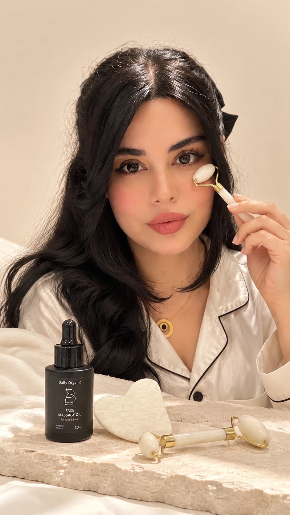 Darya using a face roller, with Daily Organic Face Massage Oil and a gua sha