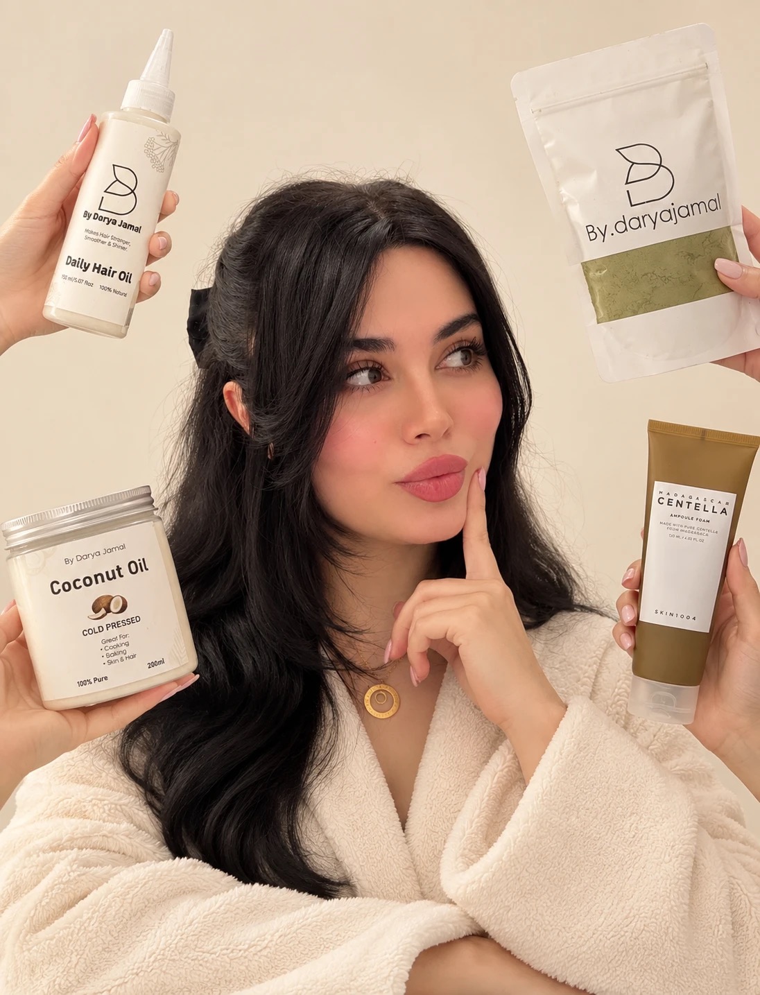 Darya holding Daily Hair Oil, coconut oil, a henna pouch and Centella foam